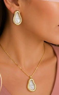 Modelo usando brinco e colar da E.M em formato de gota, com aro dourado e centro perolado
